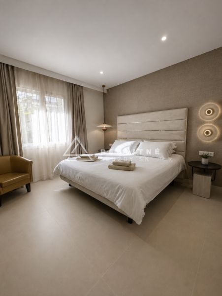 Schlafzimmer in einer 4-Zimmer-Wohnung mit Doppelbett, hellem Boden und neutralen Vorhängen.