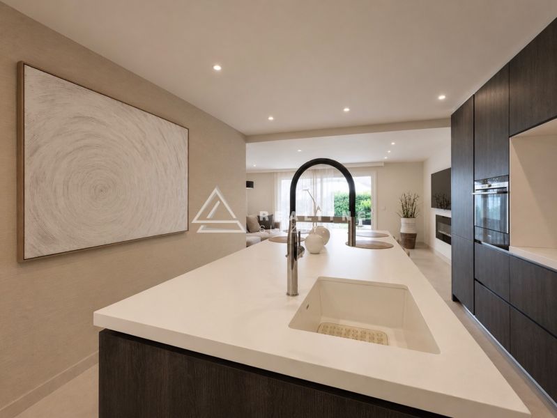 Eine Küche in einer 4-Zimmer-Wohnung mit einer Insel und eingebauten Geräten.