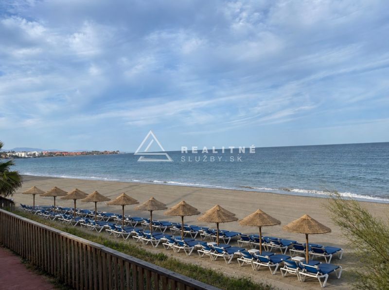 Strand bei Dominion Beach in Estepona mit Liegestühlen und Sonnenschirmen am Meer.