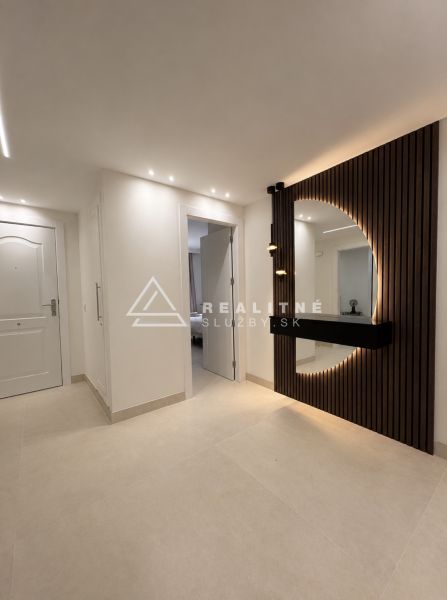 Flur in einer 4-Zimmer-Wohnung, elegante Möbel mit Beleuchtung und Designelementen an der Wand.