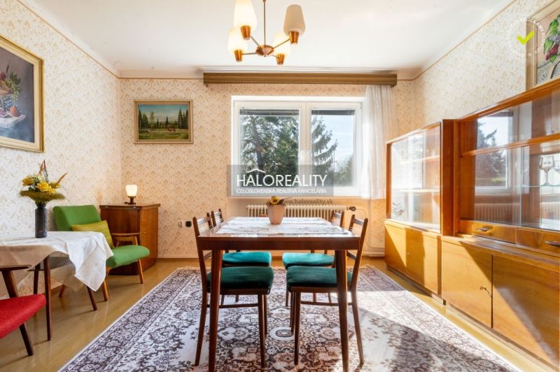 Esszimmer in einem Einfamilienhaus mit Teppichboden, Holzmöbeln und einem Tisch mit Stühlen.