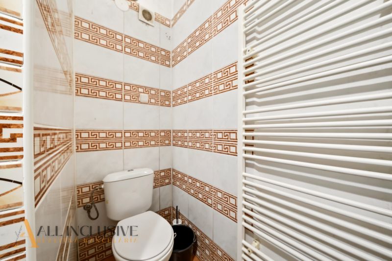 Toilette mit Fliesen im Einfamilienhaus, weiße Heizung, gemusterte Fliesen.