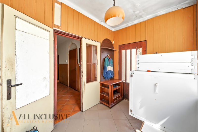 Eingangsflur eines Einfamilienhauses mit Holzverkleidung und Staumöbeln.