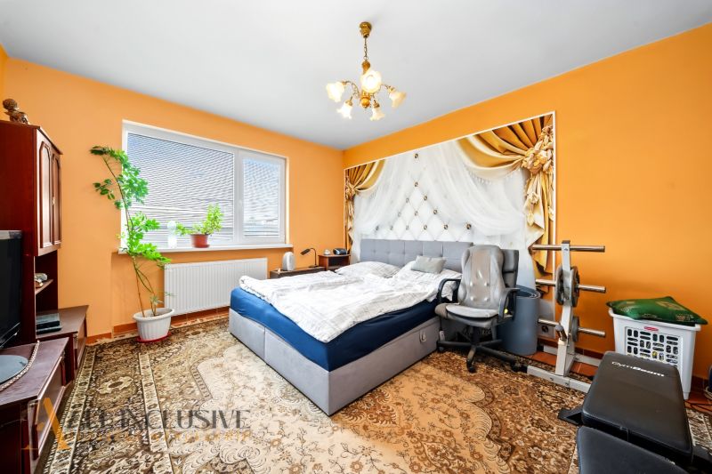 Schlafzimmer mit Bett und Fitnessgerät in einem Einfamilienhaus.