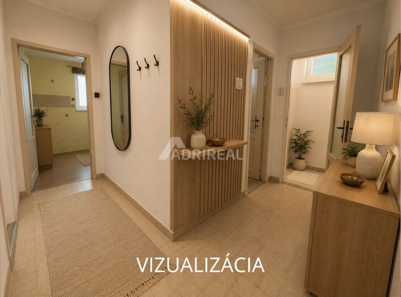 Innenraum einer 2-Zimmer-Wohnung mit Fliesen, Blumen und einem großen Spiegel an der Wand.
