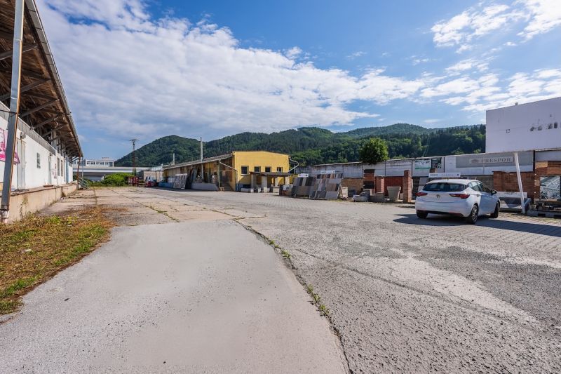 Fassade des Gebäudes an der Zvolenská-Straße, Banská Bystrica, mit Bergkulisse und Himmel.