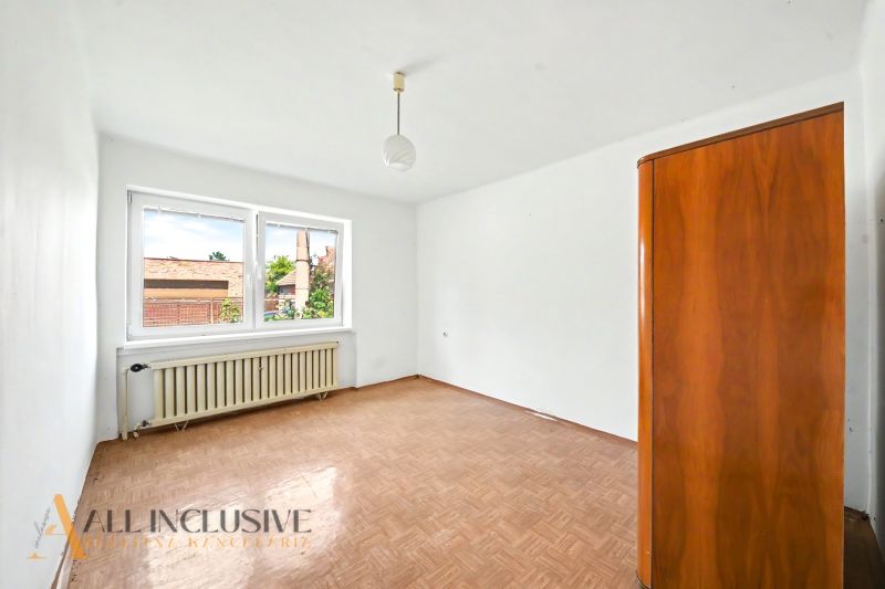 Ein leerer Raum mit einem Fenster, einem Boden in Holzoptik und einem Schrank in einem Einfamilienhaus.