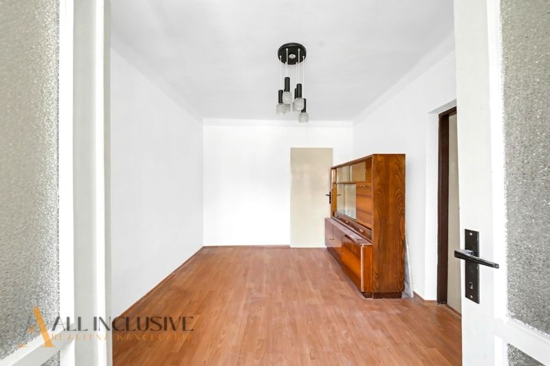Ein Zimmer mit Holzboden und einem Holzschrank in einem Einfamilienhaus.