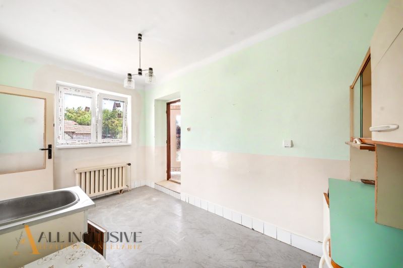 Küchenbereich in einem Einfamilienhaus mit Spüle, grünen Wänden und Heizkörper.