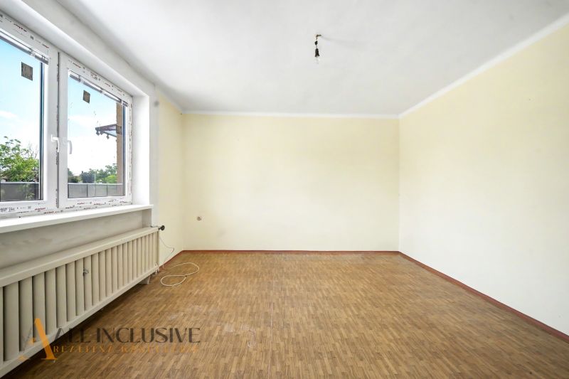 Ein leerer Raum mit Holzboden in einem Einfamilienhaus.