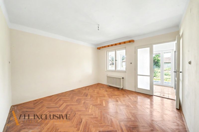 Ein heller Raum mit Holzboden und Blick in den Garten in einem Einfamilienhaus.