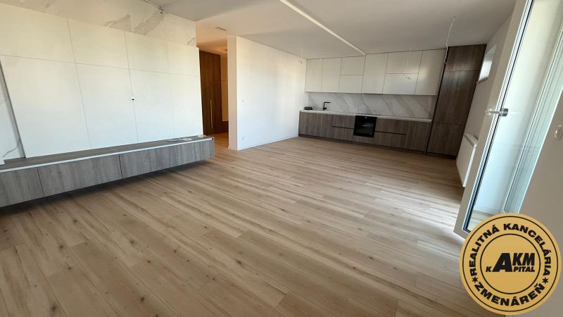 Küchenbereich einer 3-Zimmer-Wohnung mit Holzboden und weißen Schränken.