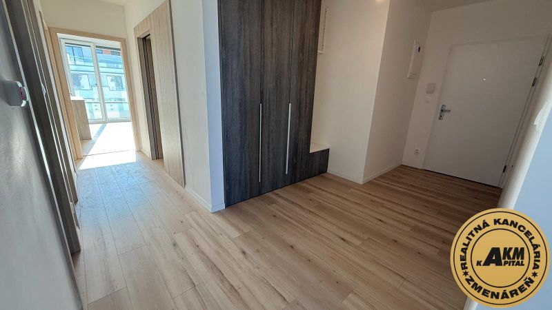 Der Flur in einer 3-Zimmer-Wohnung mit einem Holzboden und einem Einbauschrank.