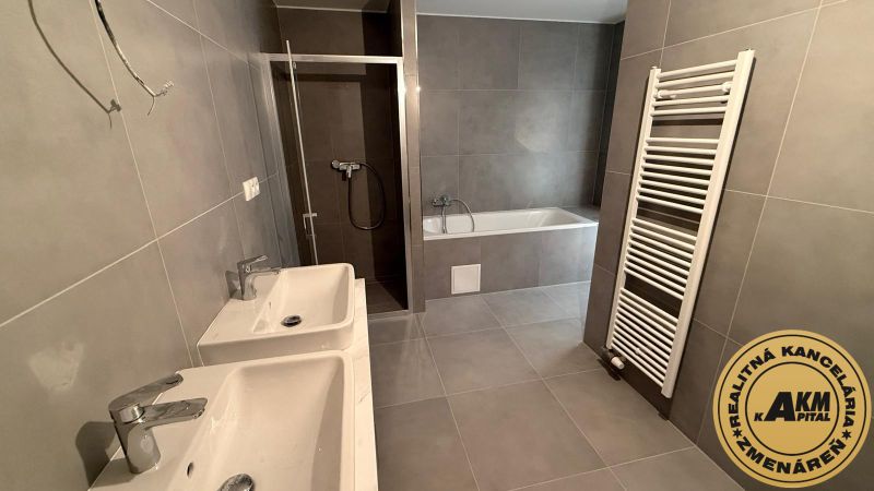 Badezimmer mit zwei Waschbecken, Badewanne und Dusche in einer 3-Zimmer-Wohnung.