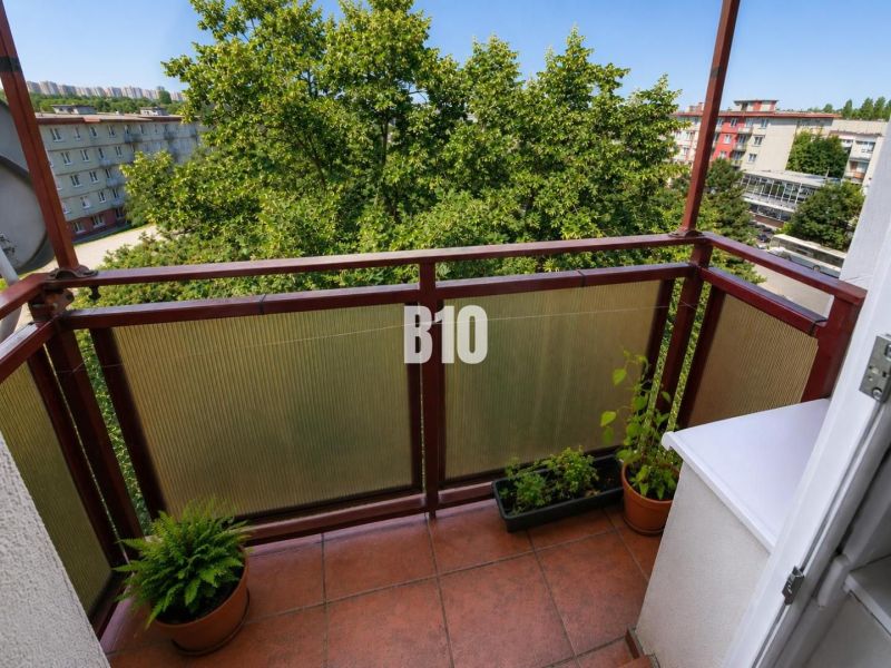 Balkon einer 2-Zimmer-Wohnung in Nitra mit Blick auf eine von Grün umgebene Siedlung.