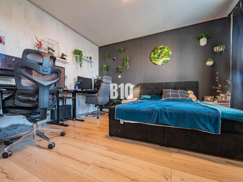 Schlafzimmer einer 3-Zimmer-Wohnung mit stilvoller Dekoration und Holzboden.