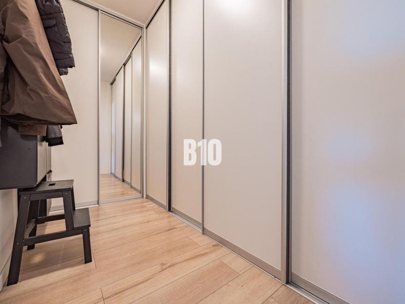 Der Flur in einer 3-Zimmer-Wohnung mit Stauraum und einem Boden in Holzoptik.