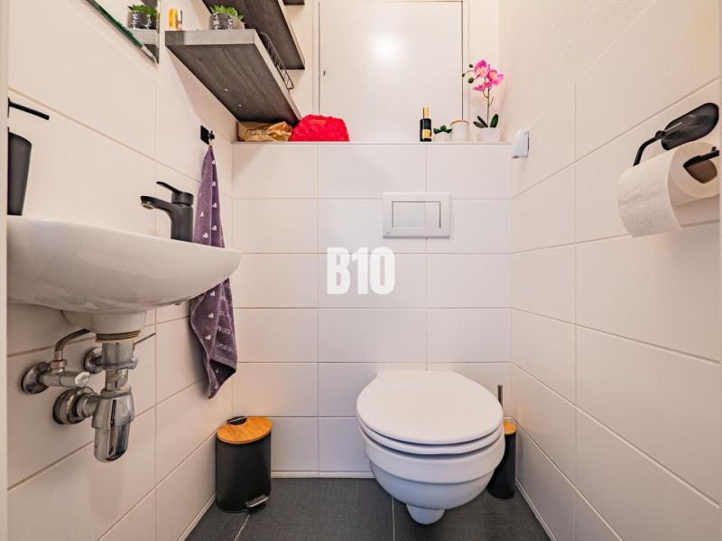 Badezimmer in einer 3-Zimmer-Wohnung, praktische Ablage, dezente Dekoration, sanitäre Einrichtungen.