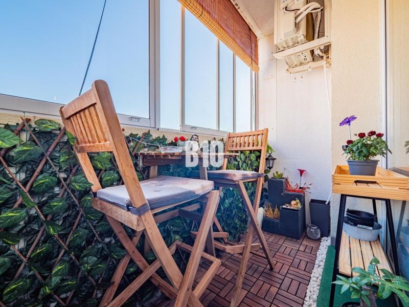 Verglaste Balkonterrasse mit Holzboden und Pflanzen in einer 3-Zimmer-Wohnung.