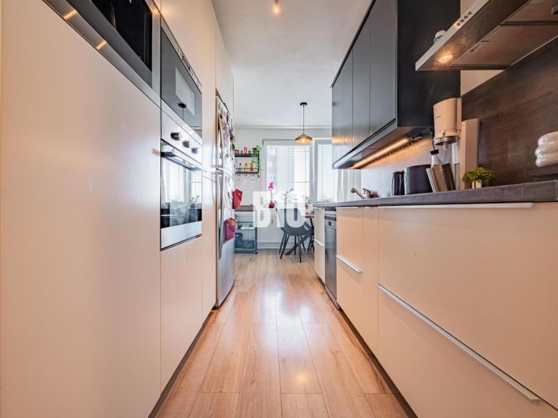 Küche in einer 3-Zimmer-Wohnung mit Holzboden und Geräten.