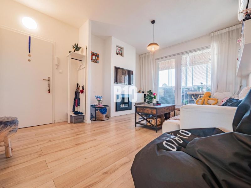 Wohnzimmer in einer 3-Zimmer-Wohnung mit Holzboden und bequemen Sitzgelegenheiten.