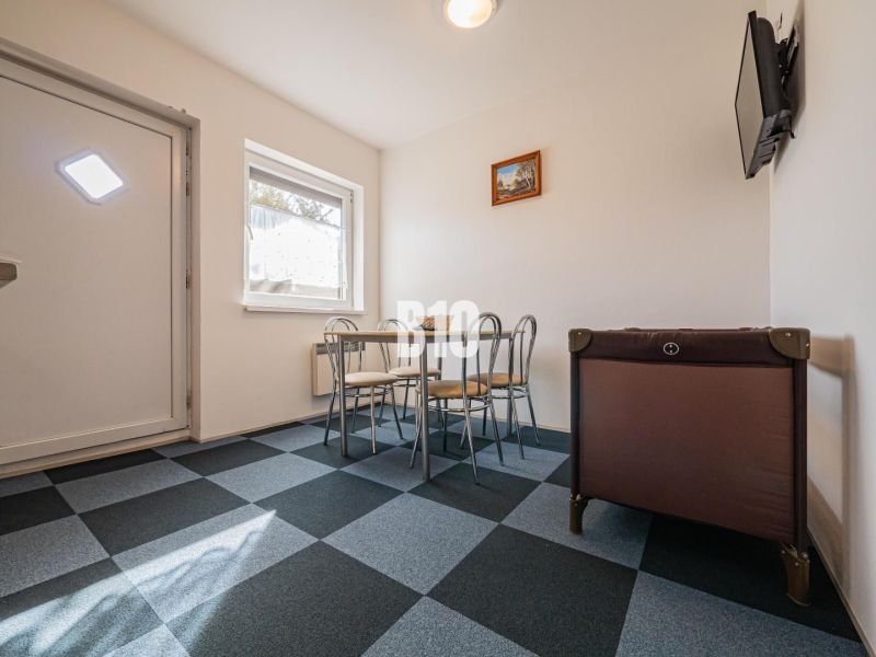 Essbereich im Einfamilienhaus mit geometrischem Boden und Kinderbett.