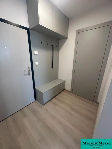 Eingangsflur in einer 2-Zimmer-Wohnung mit Holzboden und Stauraum.