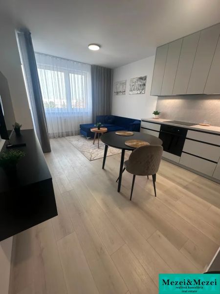 Wohnzimmer in einer 2-Zimmer-Wohnung mit Holzboden, Esstisch und Sofa.
