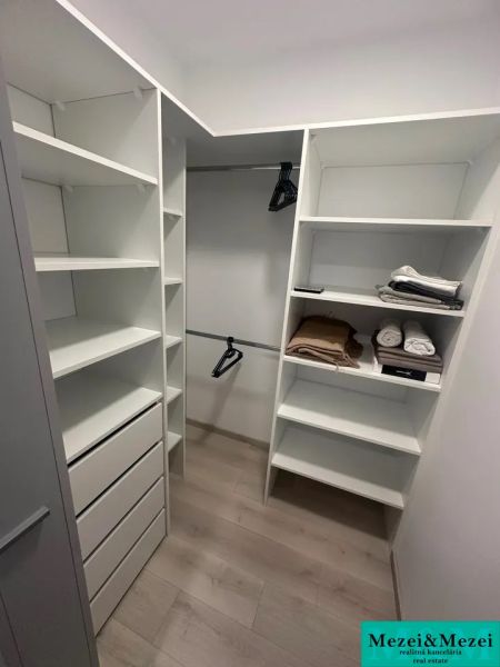 Stauraum mit Regalen, Schubladen und einem Boden mit Holzdekor in einer 2-Zimmer-Wohnung.
