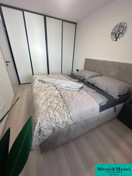 Schlafzimmer in einer 2-Zimmer-Wohnung mit Bett, Kleiderschrank und Holzboden.