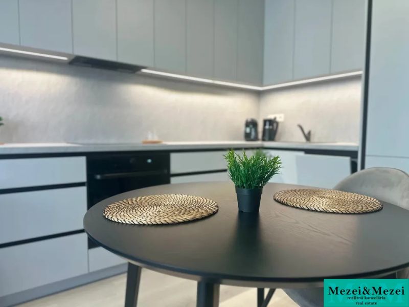 Küche in einer 2-Zimmer-Wohnung mit stilvollem Tisch und Dekorationen.