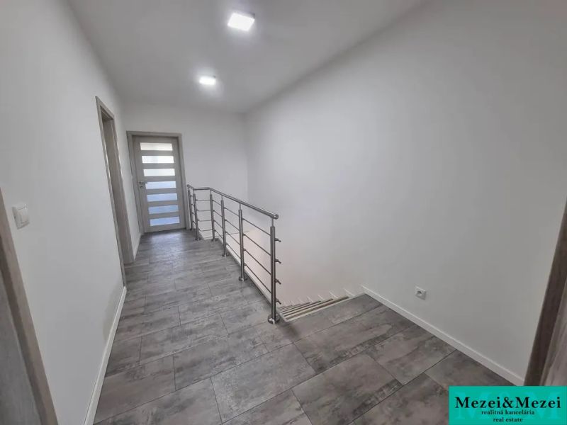 Flur in einem Einfamilienhaus mit Treppe und Keramikfliesen.