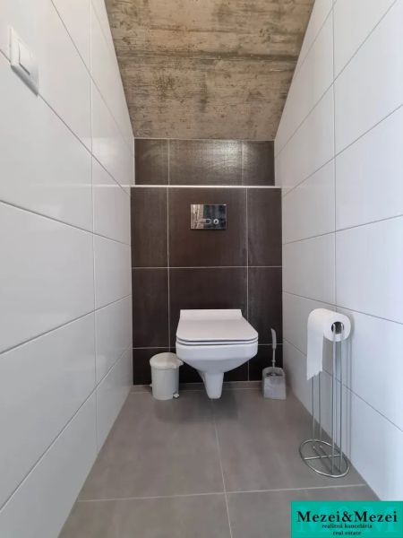 Toilette in einem Einfamilienhaus mit weißen und braunen Fliesen.