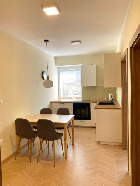 Küche mit Esstisch und Holzboden in einer 3-Zimmer-Wohnung.