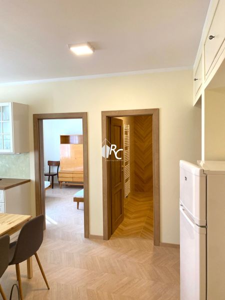 Innenraum einer 3-Zimmer-Wohnung mit Holzboden, Stühlen und Einbauschrank.