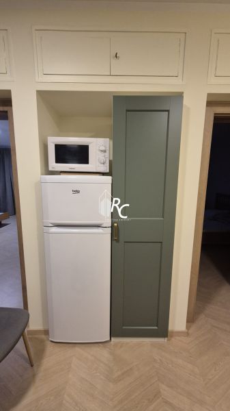Mikrowelle und Kühlschrank in der Küche einer 3-Zimmer-Wohnung mit Holzboden.