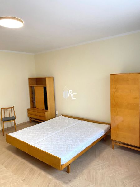 Schlafzimmer mit Bett, Schrank und Holzboden in einer 3-Zimmer-Wohnung.