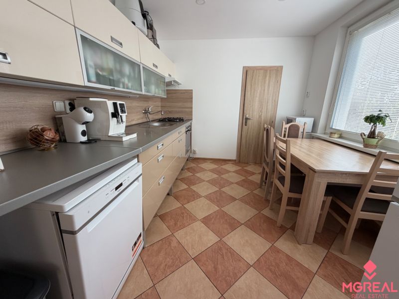 Küche in einer 3-Zimmer-Wohnung mit Esstisch, Küchenzeile und Geräten.