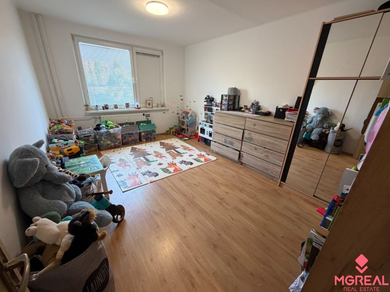 Kinderzimmer mit Spielzeug und Holzboden in einer 3-Zimmer-Wohnung.