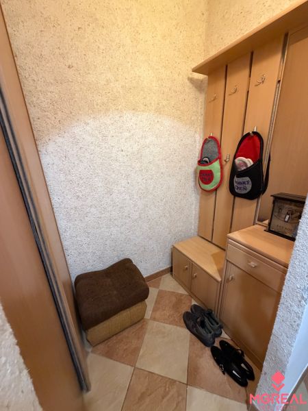 Eingangsbereich in einer 3-Zimmer-Wohnung mit Fliesenboden und einer Garderobenleiste aus Holz.