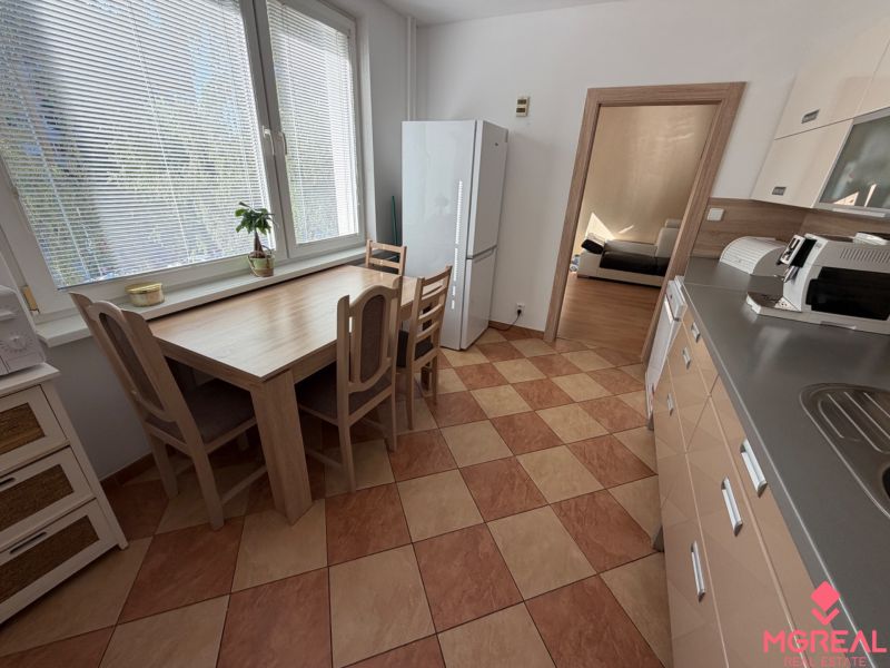 Küche in einer 3-Zimmer-Wohnung mit Fliesenboden, Esstisch und Geräten.