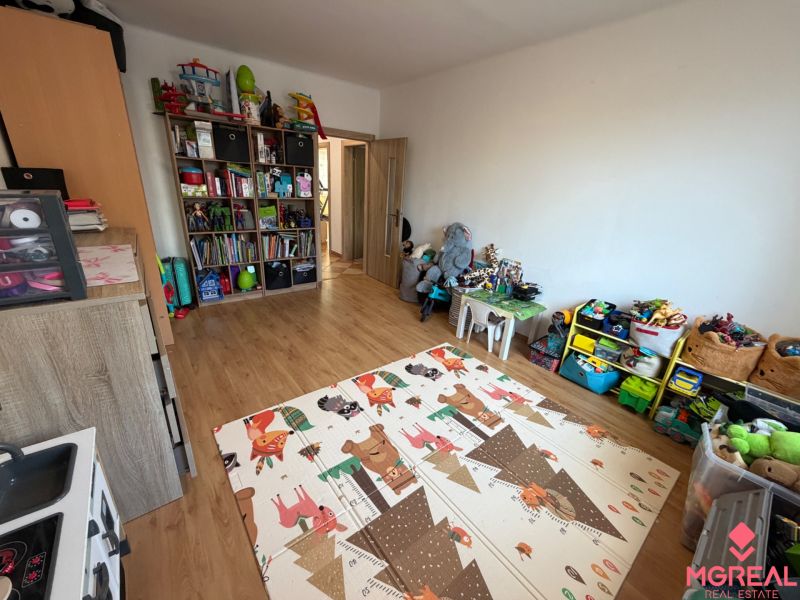 Ein Kinderzimmer mit einem Holzboden voller Spielzeug und Spiele in einer 3-Zimmer-Wohnung.