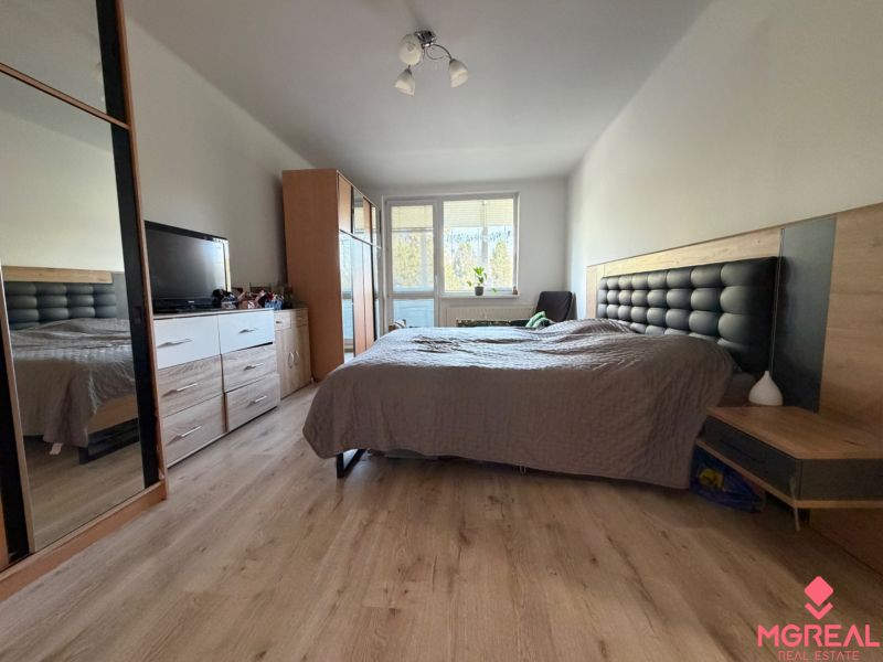 Schlafzimmer in einer 3-Zimmer-Wohnung mit Bett, Kleiderschrank und Holzboden.