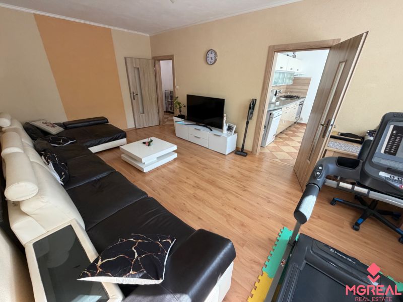 Wohnzimmer in einer 3-Zimmer-Wohnung mit Holzboden und Ledersofa.