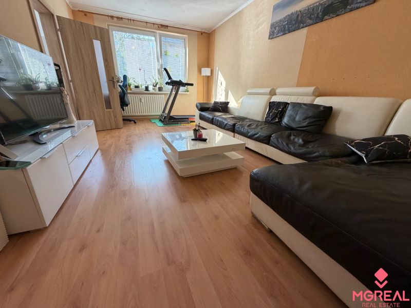Wohnzimmer mit Ledersofa und Holzboden in einer 3-Zimmer-Wohnung.