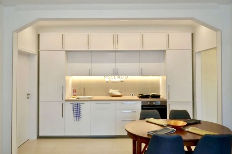 Küche in einer 3-Zimmer-Wohnung mit weißer Küchenzeile und Esstisch.