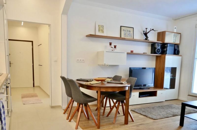Essbereich mit vier Stühlen und Fernseher in einer 3-Zimmer-Wohnung.