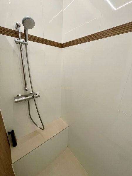 Duschkabine mit Handbrause und Fliesen in einer 3-Zimmer-Wohnung.