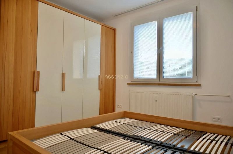 Schlafzimmer mit Bett ohne Matratze, Einbauschrank und Fenster, 3-Zimmer-Wohnung.