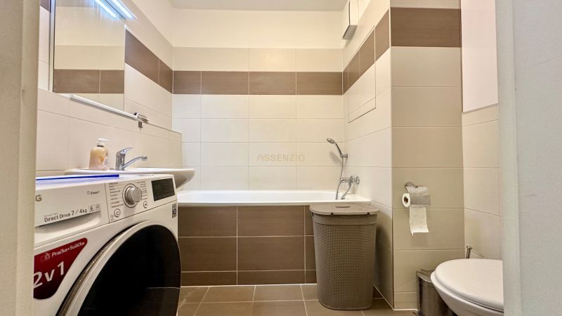 Badezimmer in einer 3-Zimmer-Wohnung mit Badewanne, Waschmaschine und Toilette.